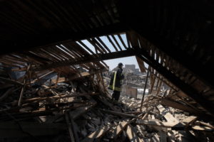 A rescue worker walks on the roof of the regional administration building that was hit by a shell in Kharkiv