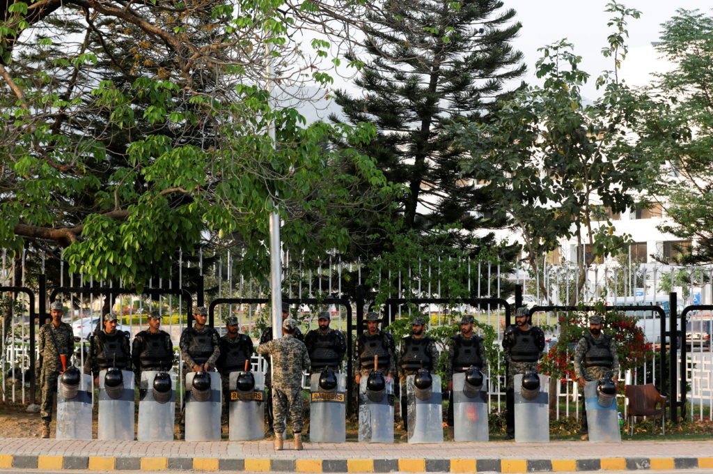 Paramilitary soldiers, with shields and helmets stand outside parliament building in Islamabad,