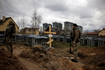 Ukrainian soldiers stand next to the grave of a civilian, who according to residents was killed by Russian soldiers, amid Russia's invasion of Ukraine, in Bucha, Kyiv region, Ukraine, April 6, 2022. Photo by Alkis Konstantinidis/REUTERS