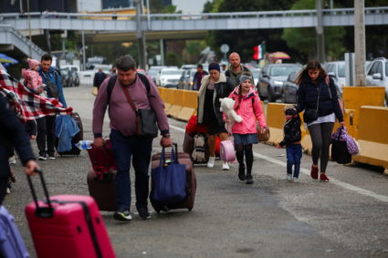 FILE PHOTO: Ukrainians who fled to Mexico amid Russia's invasion of their homeland, walk with their belongings to cross th...