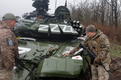 Ukrainian service members inspect a damaged Russian tank T-72 BV in Donetsk region
