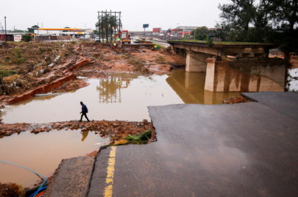 FILE PHOTO: A man walks around a damaged bridge caused by flooding in Umlazi near Durban