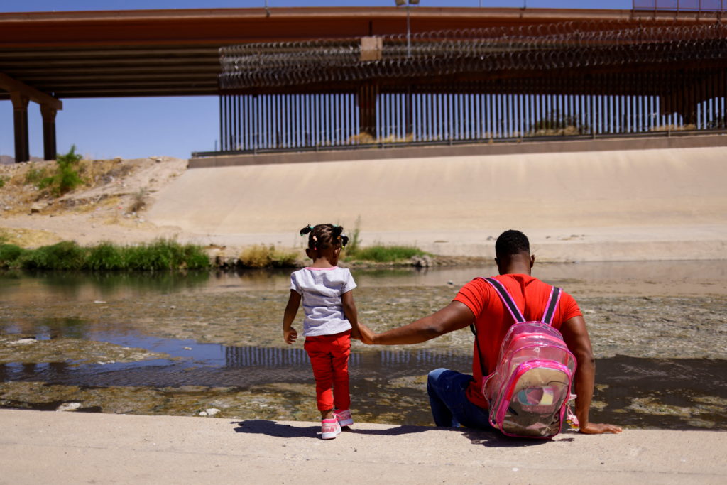 Asylum-seeking migrants from Haiti proceed to cross the Rio Bravo river to turn themselves in to U.S Border Patrol agents ...