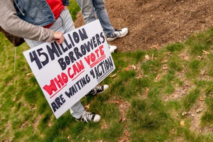 A person carries a sign during a Cancel Student Debt rally outside the US Department of Education in Washington, DC, on April 4, 2022. Photo by Stefani Reynolds/AFP via Getty Images