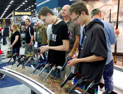 Gun enthusiasts look over Benelli USA guns at the National Rifle Association's annual meetings &amp; exhibits show in Loui...