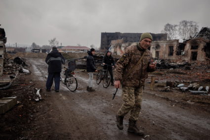 Locals walk in the demolished town center of Trostyanets after Ukrainian forces expelled Russian troops from the town whic...