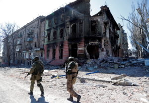 FILE PHOTO: Service members of pro-Russian troops inspect streets of Mariupol