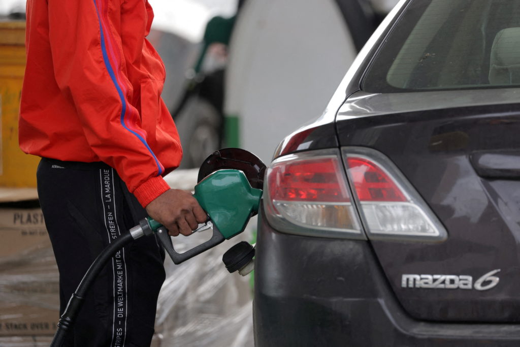 FILE PHOTO: FILE PHOTO: A person uses a petrol pump at a gas station as fuel prices surged in Manhattan, New York City