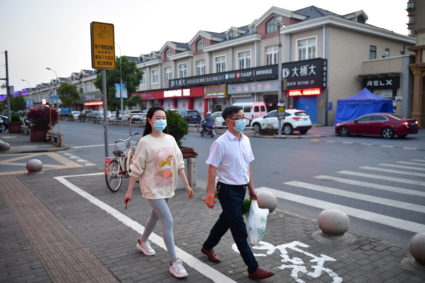 Residents walk on a street as Shanghai eases lockdown in some areas