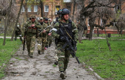 Fighters of the Chechen special forces unit walk in a courtyard in Mariupol