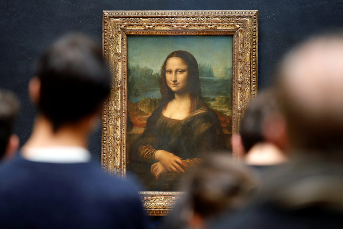 Man in wig throws cake at glass protecting Mona Lisa, shouting ‘Think
