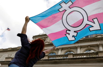 FILE PHOTO: A person holds up a flag during rally to protest the Trump administration's reported transgender proposal to n...