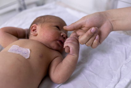 FILE PHOTO: A newborn baby holds on a nurse's finger at the maternity ward of the children hospital in Kabul