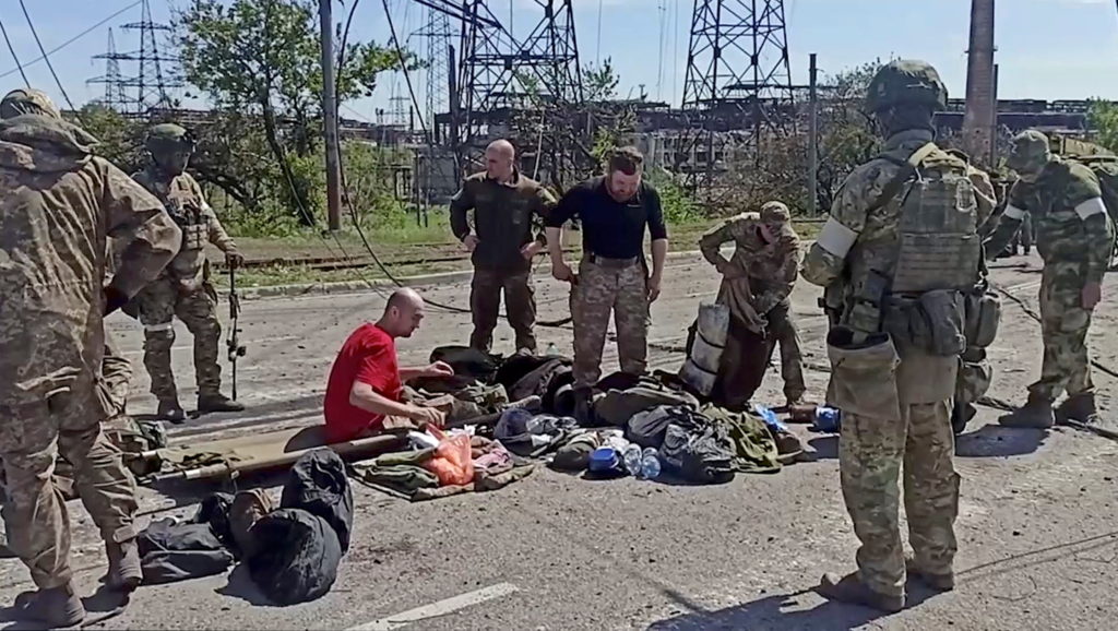 Service members of Ukrainian forces who have surrendered after weeks holed up at Azovstal steel works are being searched i...