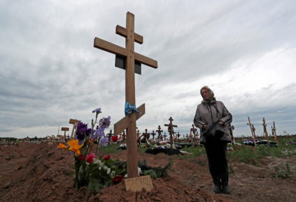 A woman visits her son's grave at a cemetery outside Mariupol