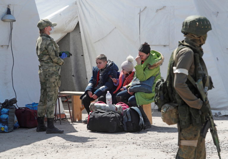 A woman sits with children at a temporary accommodation centre in Bezimenne