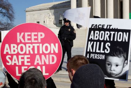 FILE PHOTO: A police officer watches pro-life and pro-choice supporters demonstrating in Washington