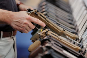 FILE PHOTO: A man inspects a handgun inside of the Beretta booth during the National Rifle Association (NRA) annual meetin...