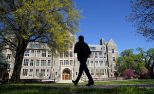 A man walks at an empty campus green at Georgetown University, closed weeks ago due to coronavirus, in Washington