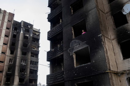 Resident Nataliia Prykhodko looks out from her burnt-out apartment in Irpin, outside Kyiv, as Russia's attacks on Ukraine ...