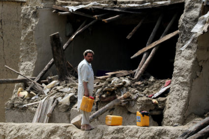 A man looks on in front of a damaged property after a recent earthquake in Gayan