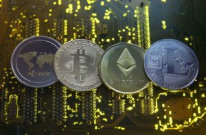 Representations of the Ripple, Bitcoin, Etherum and Litecoin virtual currencies are seen on a PC motherboard in this illustration picture, February 14, 2018. REUTERS/Dado Ruvic/File Photo