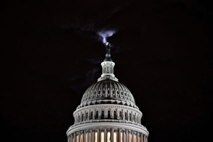 The moon is seen behind the dome of the U.S. Capitol building at night in Washington, DC, U.S., February 16, 2022. Photo by Jon Cherry/REUTERS