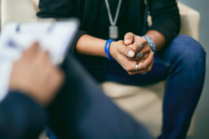 Close-up of black adolescent having a therapy session with psychologist.
