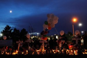 FILE PHOTO: People gather during a memorial for victims behind the theatre where a gunman opened fire on moviegoers in Aurora