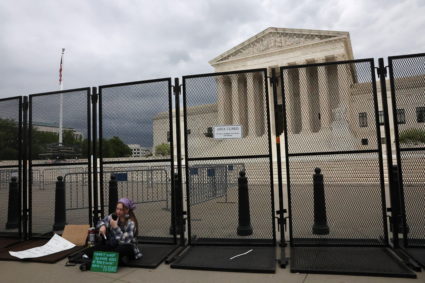 Sophia Geiger sits against an anti-climb protective fence after it was installed the night before as people rally for abortion rights, outside of the U.S. Supreme Court building in Washington, U.S., May 5, 2022. Photo by Leah Millis/REUTERS