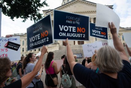 Abortion-rights supporters hold signs related to a bill that could open the door to legislation limiting or banning aborti...