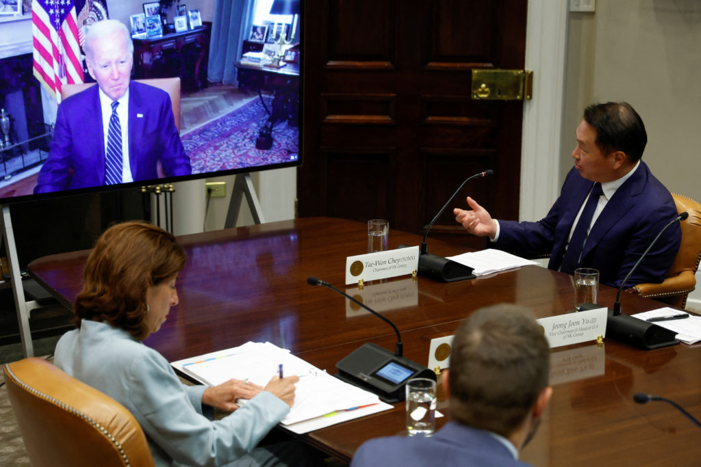 U.S. President Joe Biden, with Commerce Secretary Gina Raimondo, meets virtually with a delegation from SK Group led by Chairman Chey Tae-won, to talk about SK's plans for $22 billion in new investments in the U.S. in semiconductors, green energy and bioscience projects, from the Roosevelt Room at the White House in Washington, U.S. July 26, 2022. Photo by Jonathan Ernst/REUTERS