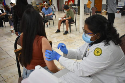Asian American person getting vaccination in arm at Mobile vaccination clinic sponsored by Eastern Michigan University Center for Health Disparities Innovations and Studies. Photo courtesy of Eastern Michigan University Center for Health Disparities Innovations and Studies.