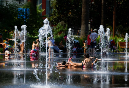 Children cool off in a fountain in Nice as a heat wave hits France