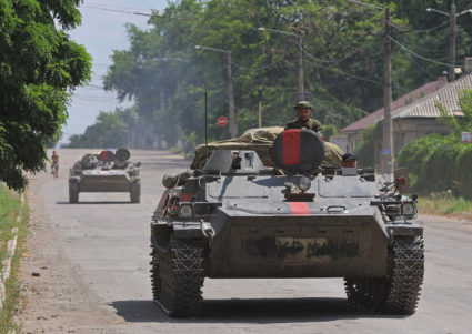 Service members of pro-Russian troops ride an infantry fighting vehicle in Lysychansk
