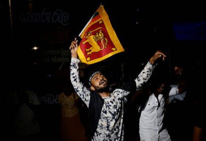 People dance as they celebrate the resignation of Sri Lanka’s President Gotabaya Rajapaksa at a protest site, amid the cou...