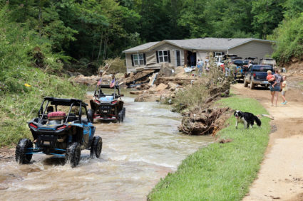 ATV drivers ferrying generator fuel and water drive around flooded home in Bowling Creek