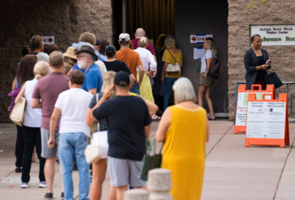 Voters wait in line to cast their ballots during the primary election in Scottsdale