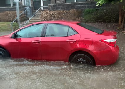 A car is parked in a flooded street in Fort Worth, Texas