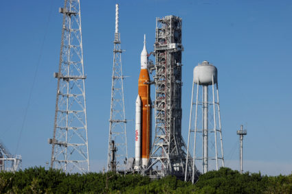 NASA’s next-generation moon rocket, the Space Launch System (SLS) rocket with its Orion crew capsule perched on top, stand...