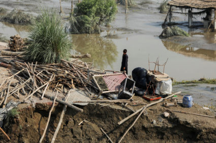 A flood victim stands amid the damages of his house, following rains and floods during the monsoon season, in Nowshera