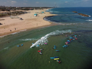 Children surf in the Mediterranean sea during a summer surf camp, at the city of Ashkelon