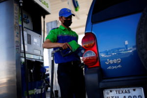 A worker fills a car belonging to a Texas resident with gasoline at a gas station following increased fuel prices in U.S.,...