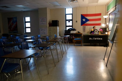 Ms. Martinez, a teacher at Iroquois High School, juggles between hers and her children's classes during a virtual learning...