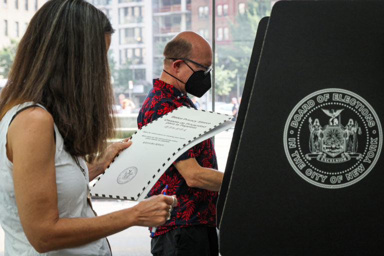 Voters submit ballots for New York's primary election at a polling station in Brooklyn, New York