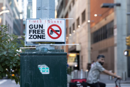 People walk past a sign that reads “gun free zone" at Times Square as new gun laws are due to come into effect, in New York, U.S., August 31, 2022. Photo by Jeenah Moon/REUTERS