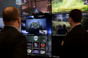 FILE PHOTO: Men look at a wall of real-time video game play in the lobby of Twitch Interactive Inc, a social video platfor...