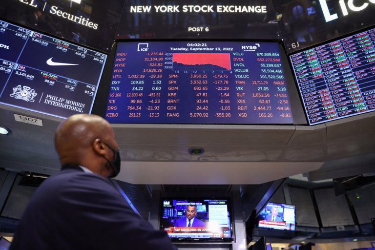 A trader looks at a screen showing the Dow Jones Industrial Average on the trading floor at the New York Stock Exchange (N...