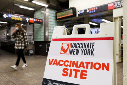 Signage for a vaccination site is seen in a subway station as the Omicron coronavirus variant continues to spread in Manha...