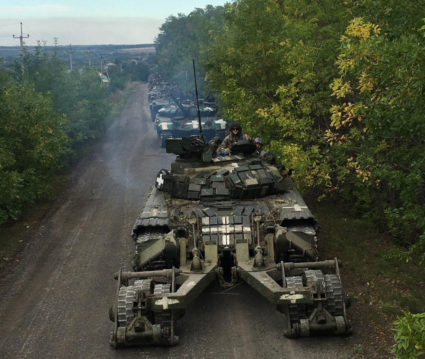 Ukrainian service members ride on tanks during a counteroffensive operation in Kharkiv region